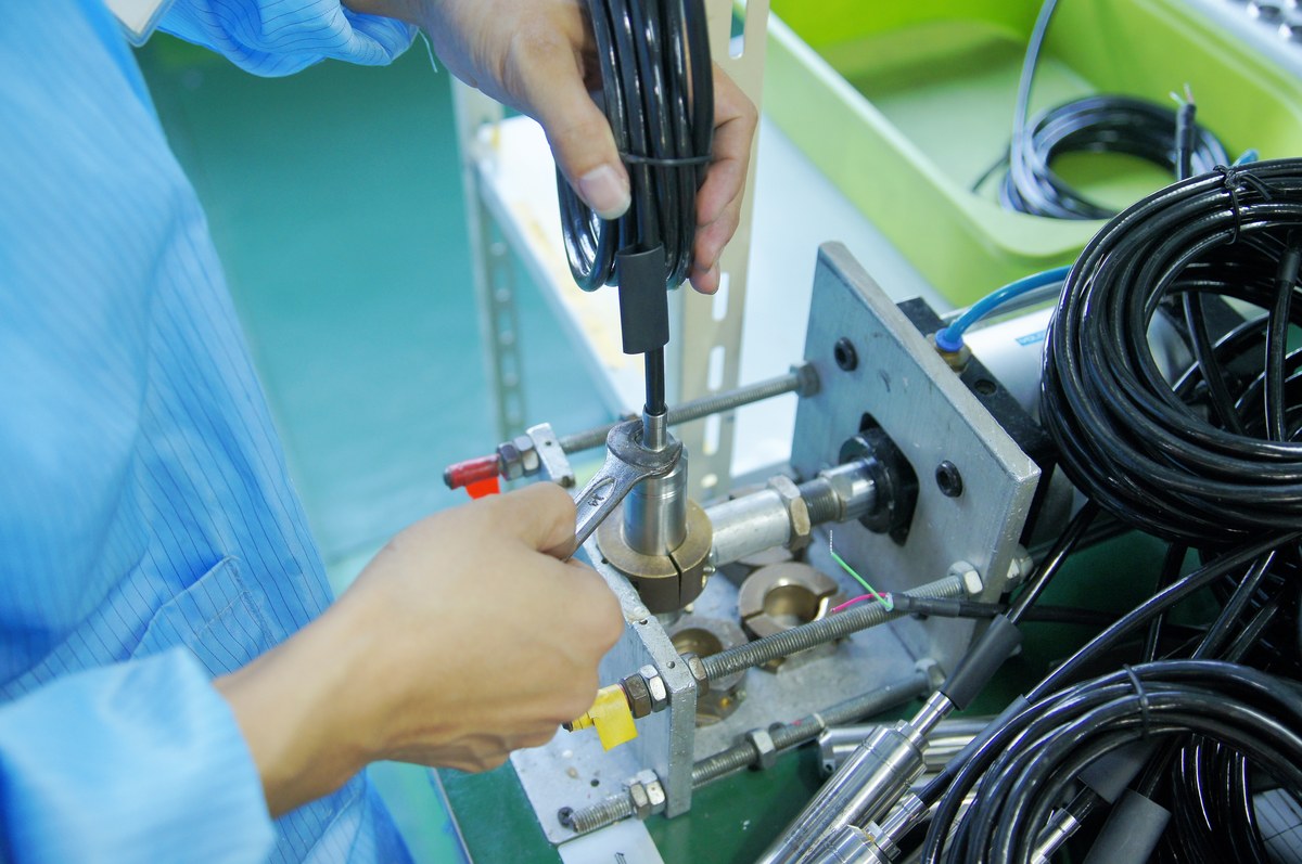 Pressure transmitter mounted on a test jig during production, with reference connections and cable